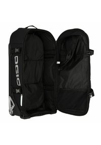 Bolsa de viaje negra con ruedas, con un amplio interior abierto, que cuenta con múltiples compartimentos, textura de tela suave y esquinas reforzadas.