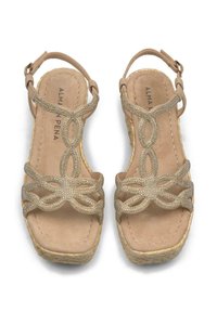 Beige wedge sandals featuring decorative metallic straps with a loop design, jute-wrapped wedge heel, and soft suede-like footbed.