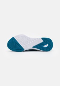 Suela de zapato con una base blanca texturizada y acentos turquesa; presenta un patrón único, proporcionando agarre y flexibilidad para actividades deportivas.