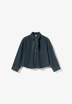 Mørkeblå denimskjorte i oversized pasform med lange ærmer, spids krave og bindedetalje ved halsen. Har knaplukning og kontrastsyninger.