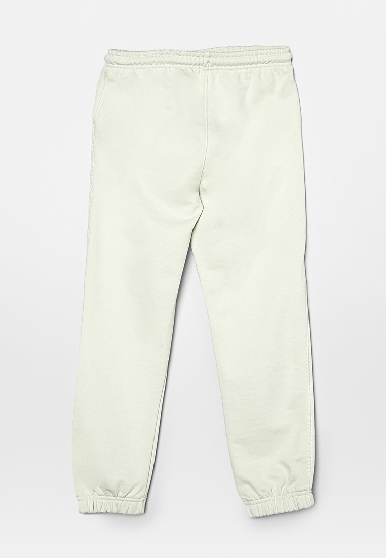 Pantaloni da jogging verde chiaro con vita elastica e polsini, caratterizzati da una texture morbida e un design affusolato. Nessun motivo o accento visibile.