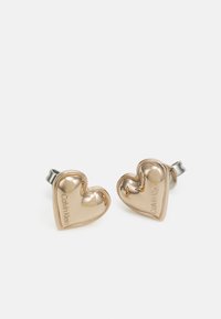 Pendientes en forma de corazón de oro con un acabado pulido. Presentan una marca en relieve. Están asegurados con un herraje en tono plata para un uso seguro.
