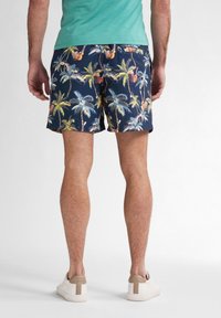 Pánské plavky s námořnickým pozadím a barevným potiskem palem a koktejlů, vyrobené z lehkého materiálu.