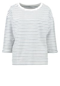 Witte T-shirt met marineblauwe horizontale strepen, ronde halslijn en driekwartmouwen. Zachte stof met een ontspannen pasvorm en zijsplitten.