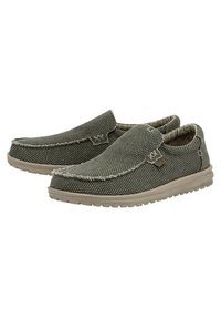 Scarpe slip-on verdi in tessuto intrecciato con superficie testurizzata, dotate di punta chiusa e dettagli in cucitura, montate su una suola in gomma beige chiaro.