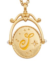 Zlatý náhrdelník s medailónom v tvare kruhu, ktorý má zlaté reliéfne písmeno "J" v žltej farbe, doplnený malými hviezdami a perlami po oboch stranách.