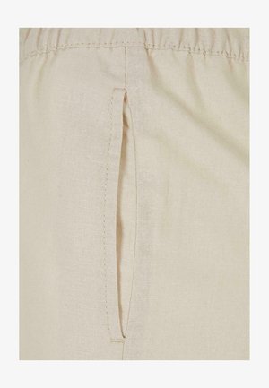 Beige stof met een textuurafwerking, voorzien van een zijzak. Het materiaal is lichtgewicht met een subtiele weefpatroon.