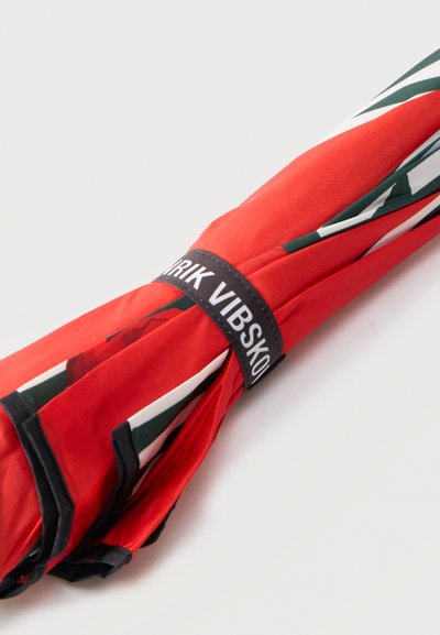 Διπλωμένη κόκκινη ομπρέλα με μαύρες και λευκές λεπτομέρειες, δεμένη με μαύρο λουρί που φέρει τη λέξη «ERIK VIBSKOV» σε ανοιχτό φόντο.