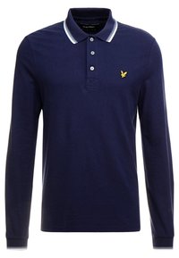 Marinblå långärmad polo skjorta, mjukt bomullsmaterial, treknappars placket, vitrandig krage och ärmslut, har en liten gul örnlogotyp på bröstet.