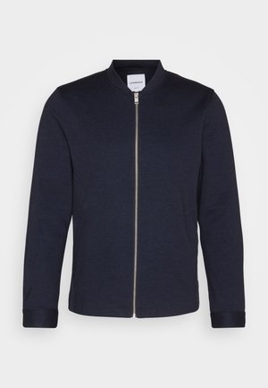 Marine bomberjakke med glidelås foran, rund krage og ribbestrikkede cuffs. Laget av et mykt stoff med en glatt tekstur, med et minimalistisk design.