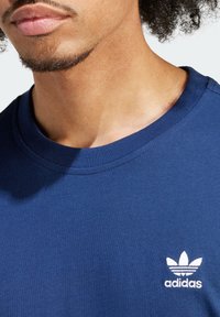 Námořnická bavlněná trička s kulatým výstřihem, na kterém je bílé vyšívané logo na levé straně hrudi a hladká textura.