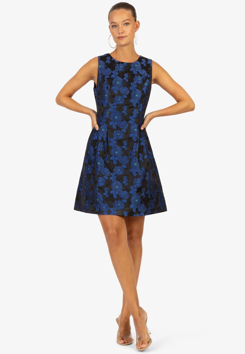 Un abito nero senza maniche con ricami floreali blu, con un corpino aderente e una gonna svasata. Tessuto morbido, design alla lunghezza del ginocchio.