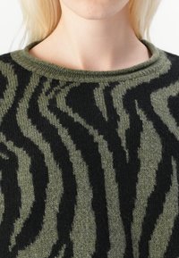 Strickpullover mit einem olivgrünen und schwarzen Zebra-Streifen-Muster, runder Halslinie und strukturiertem Stoff.