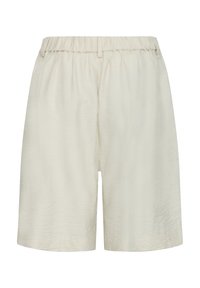 Shorts amples beiges avec taille élastique et passants pour ceinture, fabriqués en tissu léger texturé.