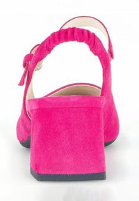 Talons ouverts en suède fuchsia avec un talon carré et un détail de sangle froncée. Texture lisse avec une semelle noire solide.