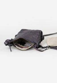 Borsa a tracolla in pelle viola con un design strutturato, chiusura con zip, fodera interna a righe e una piccola pochette coordinata.
