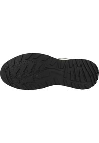 Suela de zapato de goma negra con tacos pronunciados y varios patrones para tracción. Presenta acentos de flechas direccionales y detalles perforados.