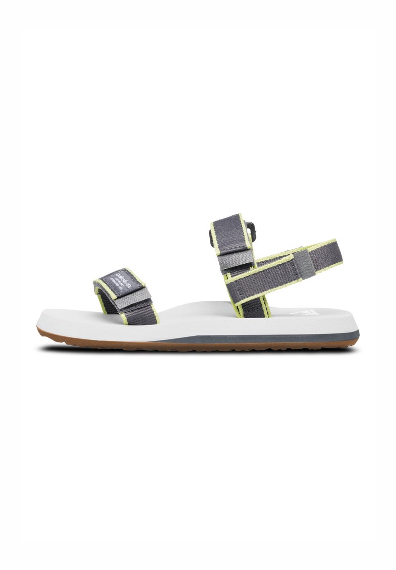 Grå sandal med limegröna accenter, som har justerbara remmar och en vit fotsäng. Texturerad sula för grepp, minimalistisk design.