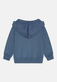 Sweatshirt à capuche en tissu bleu moyen doux. Présente des poignets et un ourlet côtelés, avec une capuche texturée. Design simple, sans motifs.