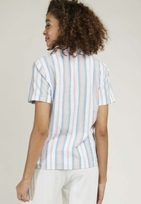Chemise à manches courtes en coton léger, avec des rayures verticales dans des couleurs pastel, dotée d'un col classique et de manches retroussées.