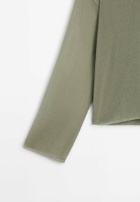 Manche longue de pull en maille vert olive avec tissu texturé visible et ourlet fini simple sur fond blanc.