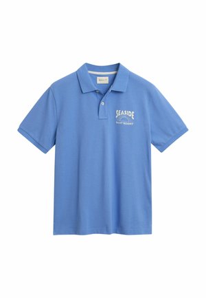 Polo shirt blu in cotone, con colletto e maniche corte. Sul davanti è presente un logo bianco con la scritta "SEASIDE" e "GANT RESORT."