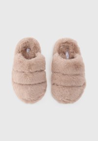 Bolygó bézs mamuszok, lekerekített orral, három vízszintes varrás kiemeléssel és puha, plüss textúrával a kényelem érdekében.