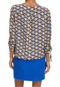 Camicia a maniche lunghe con un motivo geometrico nei colori navy, giallo e azzurro chiaro; presenta dettagli con fiocco sulle maniche e una vestibilità comoda.