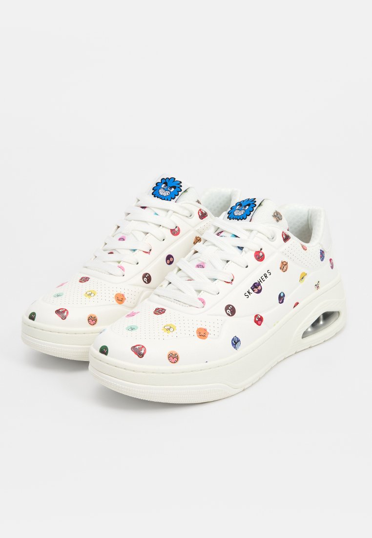 Baskets blanches avec des motifs colorés et dessinés de manière cartoon, à lacets, avec des détails perforés et une semelle épaisse avec une poche à air.