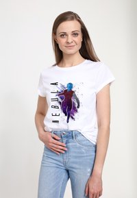 Biała koszulka z kolorową grafiką postaci "Nebula" z niebieską skórą, ubraną w fioletowy strój, obok czarnego napisu.