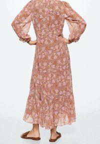 Maxikleid mit floralem Muster in Rosa- und Brauntönen, langen Puffärmeln und einem gestuften Rock. Hergestellt aus leichtem, transparentem Stoff.