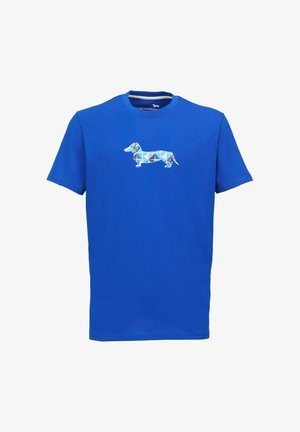 Camiseta azul de manga corta hecha de algodón, con un gráfico geométrico de un perro salchicha en tonos azules y marrones en la parte delantera.