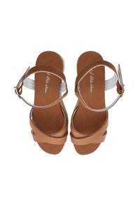 Hnědé sandály na pásky s širokým křížovým designem, hnědou stélkou a stříbrným náramkem. Zlatý přezkový detail na pásku.
