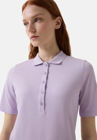 Lila Poloshirt aus strukturiertem Stoff, mit Kragen, sechs Knopfleiste und kleinem, tonalen Logo auf der Brust.