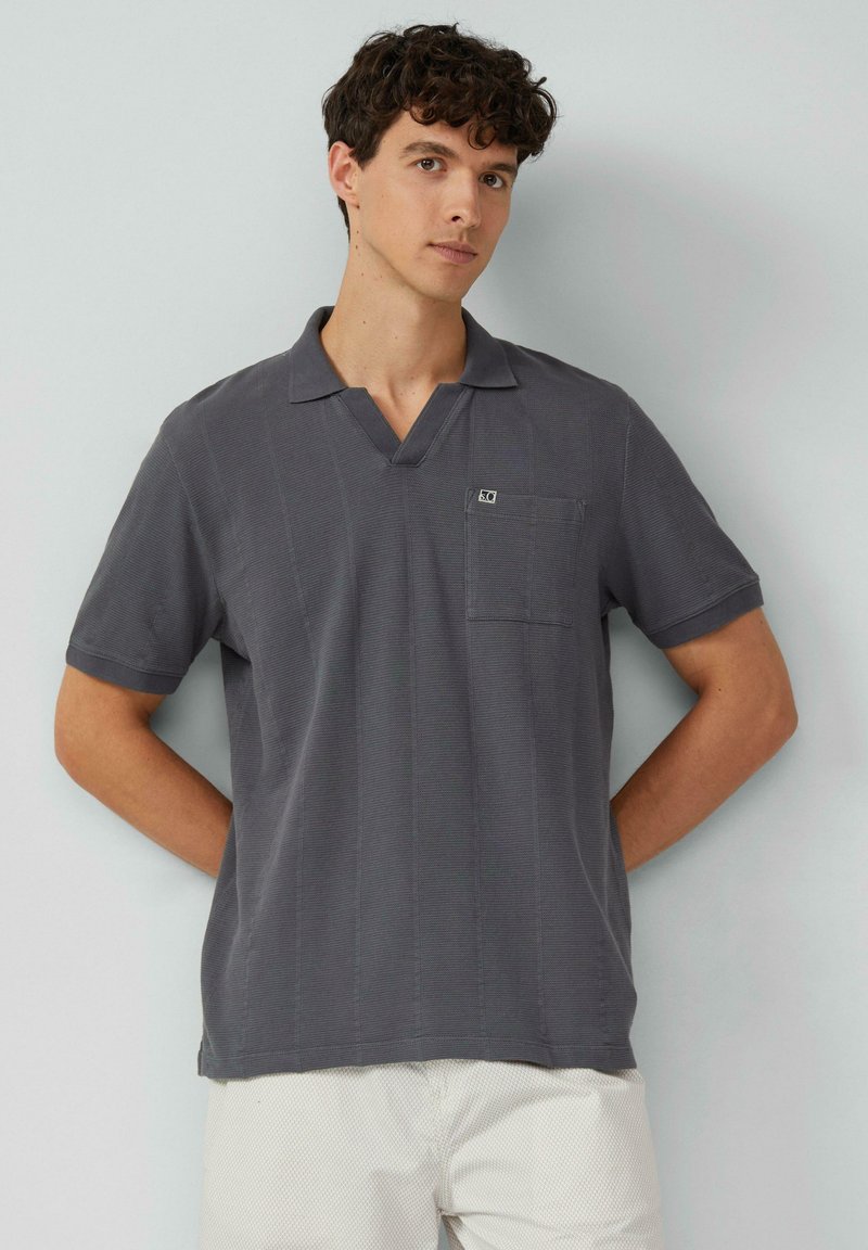 Szary krótki rękaw polo z dekoltem w serek, teksturowana tkanina, mała kieszonka na piersi i logo marki. Gładkie wykończenie i luźny krój.