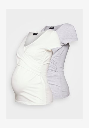 Zwei Umstandsshirts: eines in sanftem Weiß mit V-Ausschnitt und Raffung an den Seiten, und eines in hellgrau mit einem ähnlichen Design und kurzen Ärmeln.