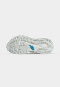 Λευκή λαστιχένια σόλα αθλητικού παπουτσιού με υφασμένα σχέδια κράτησης και μια μπλε ορθογώνια λεπτομέρεια κοντά στο κέντρο σε απλό φωτεινό φόντο.