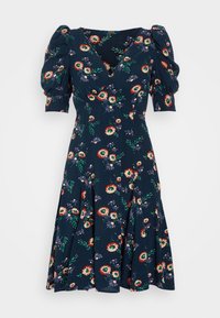 Vestido floral con escote en V profundo, mangas cortas abullonadas y falda acampanada. Presenta un fondo azul marino con flores y hojas multicolores.