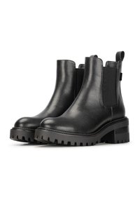 Botas Chelsea de cuero negro con paneles laterales elásticos, suela gruesa de tracción y punta redondeada. El cuero texturizado realza el interés visual.