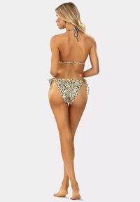 Bikini w print w panterkę z górą na halter i wiązanym dołem. Materiał wydaje się gładki. Dominujące kolory to beżowy i czarny z wzorem.