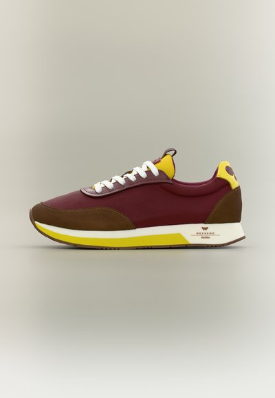 Baskets basses en mesh bordeaux avec superpositions en daim marron, lacets blancs, accents jaunes et semelle en caoutchouc blanc et jaune.
