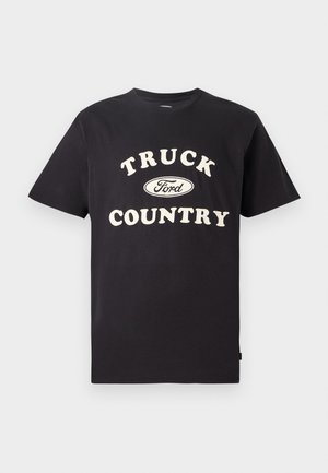 Zwarte katoenen T-shirt met korte mouwen, voorzien van "TRUCK COUNTRY" in crème tekst en een Ford-logo in het midden voorop.
