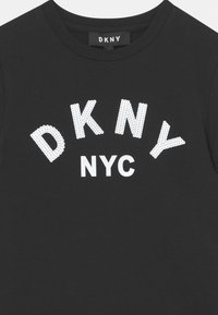 Czarny bawełniany T-shirt z odważnymi białymi literami w bloku "DKNY NYC" w perforowanym wzorze, z okrągłym dekoltem i krótkimi rękawami.