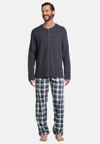 Haut henley à manches longues bleu marine avec trois boutons et pantalon de pyjama à carreaux en bleu, blanc et gris. Tissu doux, coupe décontractée.