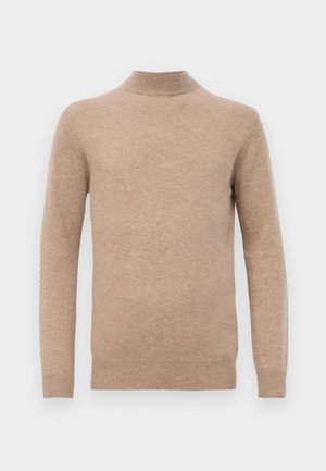 Beige pitkähihaine neulepusero, jossa on korkea kaulus ja ribboitu hihansuut sekä helma valkoista taustaa vasten.