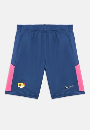 Pantalones cortos deportivos azules de tela transpirable, con paneles laterales de malla en rosa. Incluyen un logo hexagonal amarillo y el swoosh blanco de Nike.