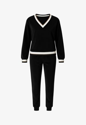 Zwart trainingspak bestaande uit een sweatshirt met V-hals, afgewerkt met ribbelige witte en gouden details, en bijpassende tapered broek met ribbelige manchetten.