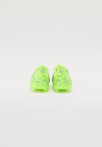 Des chaussures de soccer jaune-vert vif avec un motif texturé, dotées d'un design léger et de plusieurs crampons pour une traction sur le gazon.
