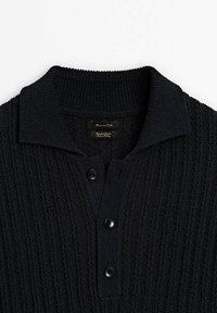 Pull noir en maille avec texture côtelée, trois boutons noirs sur le devant et un large col.