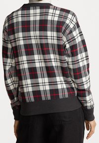 Kariertes Sweatshirt in Schwarz, Weiß und Rot mit geripptem Saum und Bündchen. Verfügt über ein Schachbrettmuster mit unterschiedlichen Größen und geometrischen Formen.